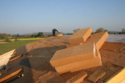 Photo représentant une toiture en construction avec des blocs de laine
		de bois en premier plan